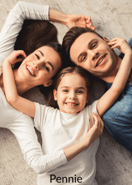 Happy mother, father, and young daughter lying on a wooden floor, smiling and looking up.